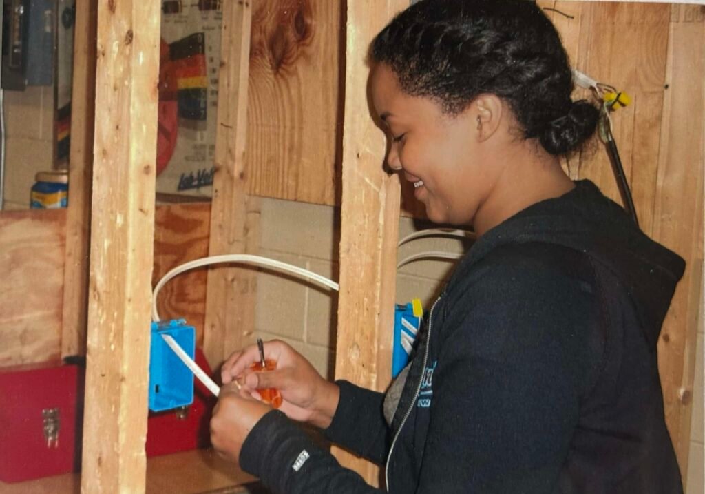 Student working on wiring an electrical outlet during training.